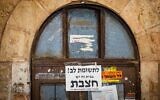 A notice warning of 'measles' is seen on a door in the ultra-Orthodox neighborhood of Mea Shearim in Jerusalem, July 31, 2025. (Chaim Goldberg/Flash90)