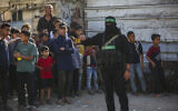 Members of the Qassam Brigades control crowds in the Nuseirat refugee camp in the central Gaza Strip, October 28, 2025. (Ali Hassan/Flash90)