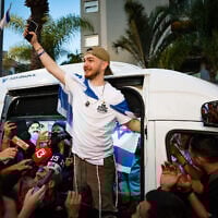 Freed hostage Bar Kuperstein is greeted by well-wishers as he arrives at his home in Holon, November 2, 2025. (Flash90)