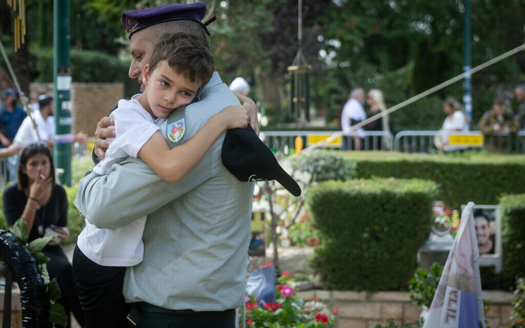 Col. Tal Ashur holds Alon Hamami, son of Col. Asaf Hamami, during Col. Hamami's funeral in Kiryat Shaul Cemetery in Tel Aviv, November 4, 2025. Hamami was killed in battle on October 7, 2023. His body was held by Hamas terrorists in Gaza and released to Israel on November 2, 2025. Ashur, a close friend, also eulogized Hamami at the funeral. (Chaim Goldberg/Flash90)