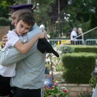 Col. Tal Ashur holds Alon Hamami, son of Col. Asaf Hamami, during Col. Hamami's funeral in Kiryat Shaul Cemetery in Tel Aviv, November 4, 2025. Hamami was killed in battle on October 7, 2023. His body was held by Hamas terrorists in Gaza and released to Israel on November 2, 2025. Ashur, a close friend, also eulogized Hamami at the funeral. (Chaim Goldberg/Flash90)