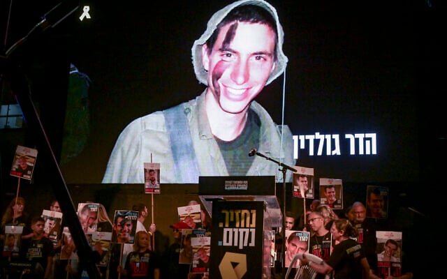 An image of slain captive Lt. Hadar Goldin is shown on the screen during a protest at Hostages Square in Tel Aviv calling for the release of the remaining hostages held by Hamas, November 8, 2025. (Avshalom Sassoni/Flash90)