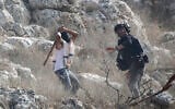 An Israeli settler attacks a journalist during the olive-picking season in the village of Beita, south of Nablus in the West Bank, November 8, 2025. (Nasser Ishtayeh/ Flash90)