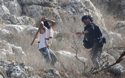 An Israeli settler attacks a journalist during the olive-picking season in the village of Beita, south of Nablus in the West Bank, November 8, 2025. (Nasser Ishtayeh/ Flash90) An Israeli settler attacks a journalist during the olive-picking season in the village of Beita, south of Nablus in the West Bank, November 8, 2025. (Nasser Ishtayeh/ Flash90)