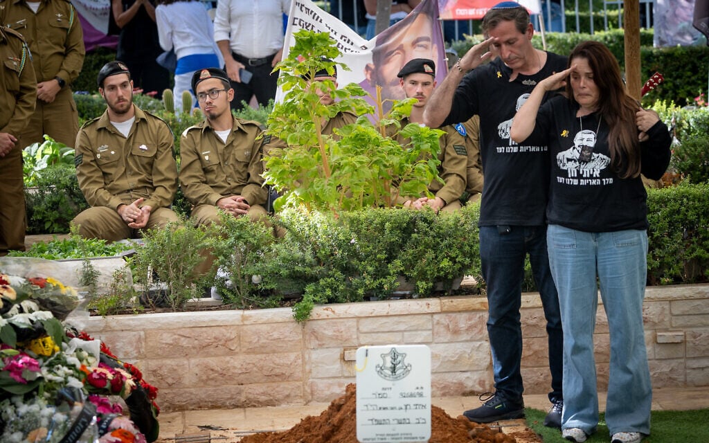 Ruby and Hagit, the parents of Staff Sgt. Itay Chen, salute their son at his funeral at the military cemetery in Kiryat Shaul Cemetery in Tel Aviv on November 9, 2025 (Chaim Goldberg/Flash90)
