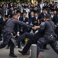 Police detain an ultra-Orthodox man during a protest against Haredi enlistment to the IDF outside a military recruitment center in Jerusalem, November 12, 2025. (Chaim Goldberg/Flash90)
