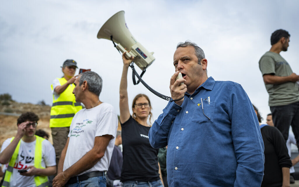 Labor MK Gilad Kariv protests at a checkpoint near the West Bank city of Ariel after police stopped at least seven buses that were on their way to a mass olive harvest in support of Palestinians facing attacks by extremist settlers, November 14, 2025. (Erik Marmor/Flash90)