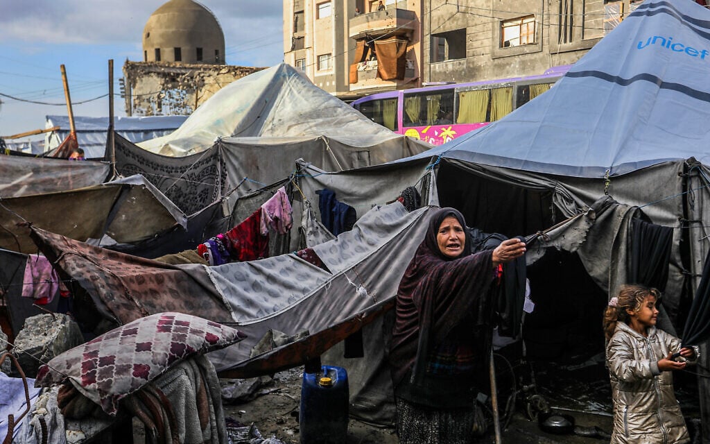 Palestinians remove water from their tents after a rain storm at the Austrian Quarter in Khan Younis, in the southern Gaza Strip, November 16, 2025 (Abed Rahim Khatib/Flash90)