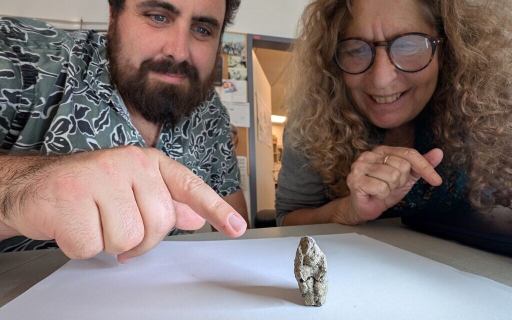 Dr. Laurent Davin and Prof. Leore Grosman and from the Hebrew University with a 12,000-year-old Natufian clay figurine from Nahal Ein Gev II near the Sea of Galilee, depicting a woman and a goose. Its discovery was announced in a PNAS study on November 17, 2025. (Hadas Goldgeier/Hebrew University of Jerusalem)