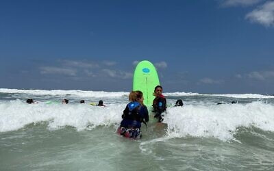 Women from Kibbutz Nir Oz close to the Gaza border meet with HaGal Sheli for a surfing lesson on the Ashkelon coast, September 3, 2025. (Courtesy of HaGal Sheli)