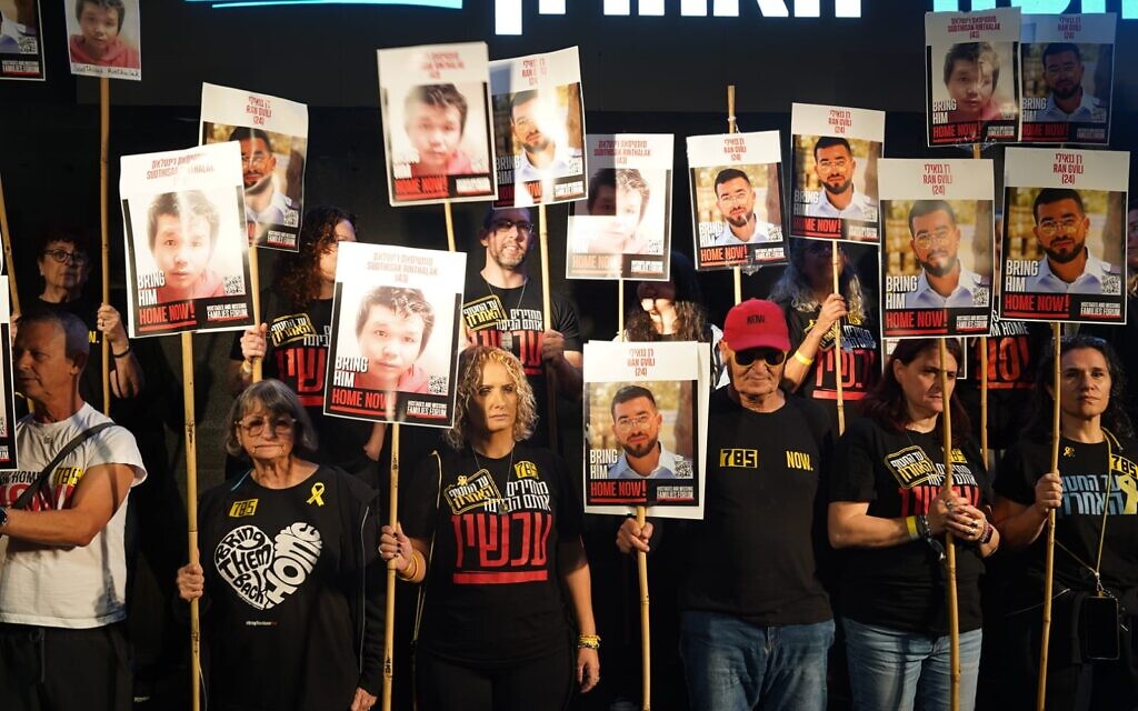 Families of the two remaining deceased hostages and relatives of former hostages hold images of the two men, Ran Gvili and Sudthisak Rinthalak, in Hostages Square, Tel Aviv, on November 29, 2025. (Dana Reany/Pro-Democracy Protest Movement) Families of the two remaining deceased hostages and relatives of former hostages hold images of the two men, Ran Gvili and Sudthisak Rinthalak, in Hostages Square, Tel Aviv, on November 29, 2025. (Dana Reany/Pro-Democracy Protest Movement)