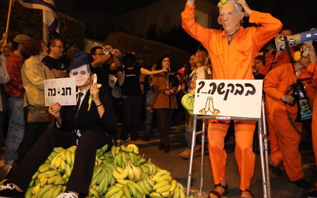 A person dressed as Prime Minister Benjamin Netanyahu in a prison jumpsuit asks for a pardon from another protester dressed as President Isaac Herzog, at the "Banana Republic" protest outside Herzog's home in Tel Aviv, on November 30, 2025. (Yossi Yaron/Pro-Democracy Protest Movement) A person dressed as Prime Minister Benjamin Netanyahu in a prison jumpsuit asks for a pardon from another protester dressed as President Isaac Herzog, at the "Banana Republic" protest outside Herzog's home in Tel Aviv, on November 30, 2025. (Yossi Yaron/Pro-Democracy Protest Movement)