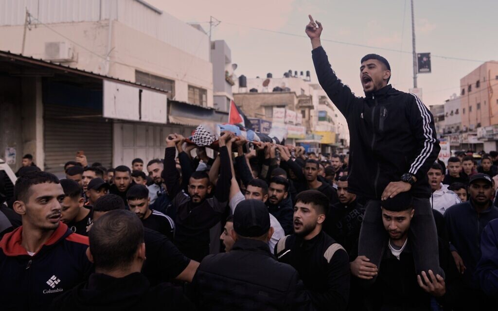 Mourners carry the body of the Palestinian Hassan Ahmed Jamil Moussa, 19, who according to health authorities, was killed during an Israeli raid, during his funeral in the Askar camp near the West Bank city of Nablus, Sunday, Nov. 16, 2025. (AP Photo/Majdi Mohammed)
