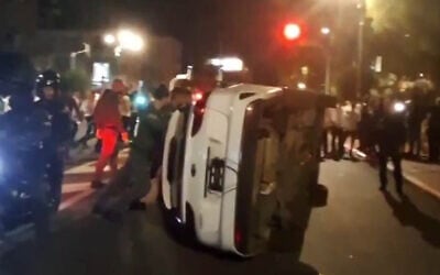 Screen capture from video of a Military Police car overturned by anti-draft ultra-Orthodox protesters in Ramat Gan, November 26, 2025. (X) Screen capture from video of a Military Police car overturned by anti-draft ultra-Orthodox protesters in Ramat Gan, November 26, 2025. (X)