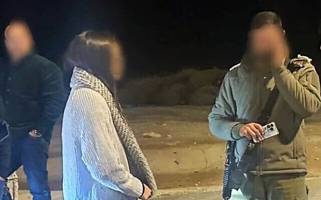 An Israeli woman who was extracted from the West Bank city of Jericho is seen next to an officer from the Civil Administration on December 31, 2025. (Courtesy)
