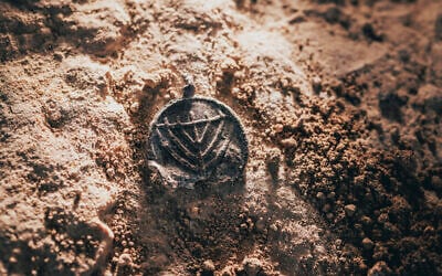 A 1,300-year-old menorah-decorated pendant was found at the Davidson Archaeological Park in Jerusalem, in a discovery announced on December 15, 2025. (Eliyahu Yanai/City of David)