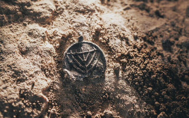 A 1,300-year-old menorah-decorated pendant was found at the Davidson Archaeological Park in Jerusalem, in a discovery announced on December 15, 2025. (Eliyahu Yanai/City of David)