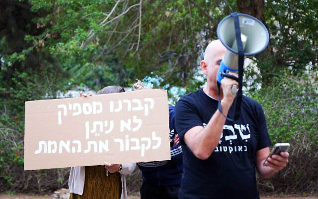 A protest outside the home of Knesset Speaker Amir Ohana in Tel Aviv on December 24, 2025. The sign reads, 'We have buried enough -- you cannot bury the truth.' (Pro-democracy protest groups/Lior Segev) A protest outside the home of Knesset Speaker Amir Ohana in Tel Aviv on December 24, 2025. The sign reads, 'We have buried enough -- you cannot bury the truth.' (Pro-democracy protest groups/Lior Segev)