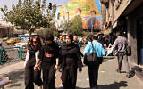 Iranian women walk in front of a billboard depicting slain Hezbollah leader Hassan Nasrallah (C) and his successor Hashem Safieddine (R) as well as the late Iranian General Qasem Soleimani, in Tehran on September 28, 2025.(Atta Kenare/AFP)