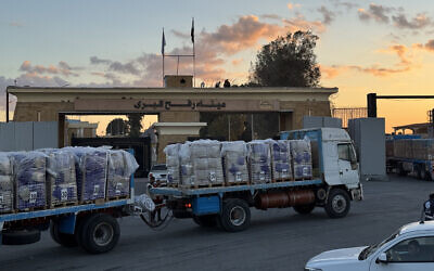Trucks loaded with humanitarian aid on the Egyptian side of the Rafah Border Crossing wait to cross into the Gaza Strip, early on October 15, 2025. (AFP)