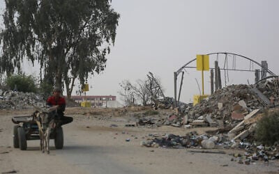 A Palestinian man rides on a cart pulled by a donkey near a concrete block marking the Yellow Line drawn by the Israeli military in Bureij, central Gaza Strip, on November 4, 2025. (Bashar Taleb / AFP) A Palestinian man rides on a cart pulled by a donkey near a concrete block marking the Yellow Line drawn by the Israeli military in Bureij, central Gaza Strip, on November 4, 2025. (Bashar Taleb / AFP)
