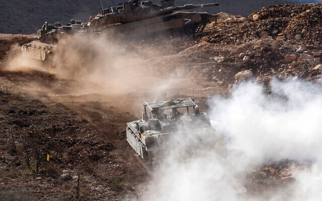 Israeli  tanks patrol close to the border fence separating northern Israel from southern Lebanon on November 24, 2025.  (Photo by Jalaa MAREY / AFP)