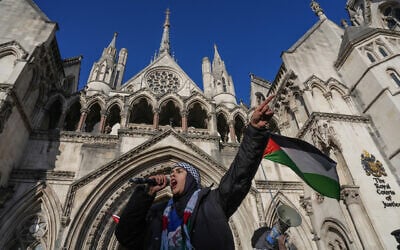 A protester takes part in a demonstration in support of Palestine Action, outside the Royal Courts of Justice, Britain's High Court, in central London on November 26, 2025. (CARLOS JASSO / AFP)