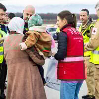 A woman with her baby disembark after landing to Geneva Airport, in Geneva, for medical treatment, on November 28, 2025. (SALVATORE DI NOLFI / POOL / AFP)