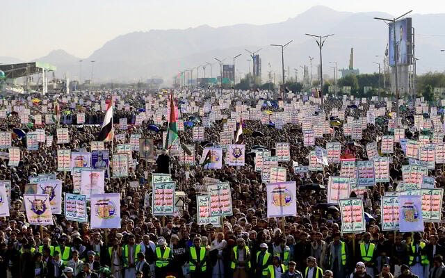Supporters of Yemen's Houthis raise placards and flags during a rally marking Independence Day, the anniversary of the end of British rule in southern Yemen in 1967, in the Houthi-controlled Yemeni capital Sanaa on November 30, 2025. (Mohammed HUWAIS / AFP)