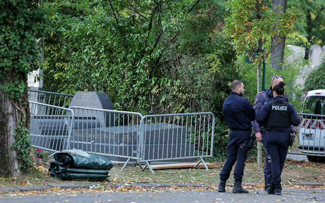 French police officers stand next to the grave of former French justice minister Robert Badinter, which had been vandalized, at the Bagneux cemetery in Bagneux, near Paris, on October 9, 2025. (Thomas SAMSON / AFP)