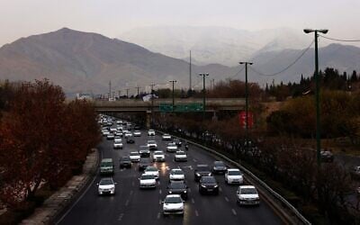 A general view shows the Iranian capital Tehran with the snow-covered Alborz mountain range in the background on December 8, 2025. (ATTA KENARE / AFP)