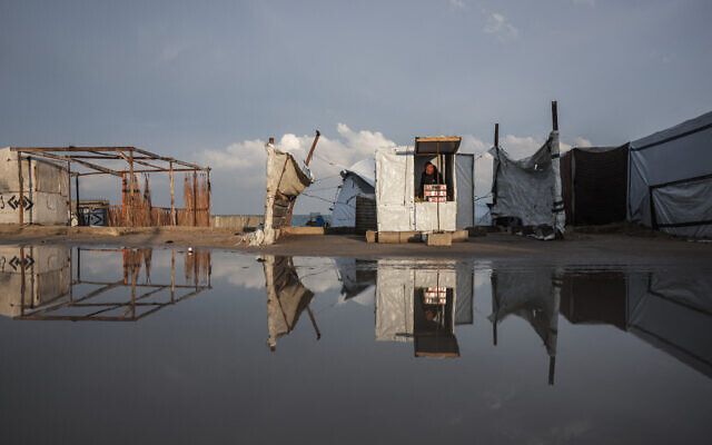 A man sets up his makeshift shop along a flooded road in Deir al-Balah, in the central Gaza Strip, on December 10, 2025 (BASHAR TALEB / AFP) A man sets up his makeshift shop along a flooded road in Deir al-Balah, in the central Gaza Strip, on December 10, 2025 (BASHAR TALEB / AFP)