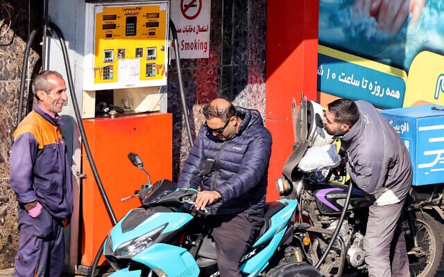 موتورسوارانی در حال سوخت‌گیری در پمپ بنزینی در تهران، ایران، ۱۳ دسامبر ۲۰۲۵.