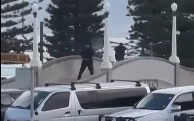 This screen grab made from UGC handout video footage courtesy of Timothy Brant-Coles shows two gunmen dressed in black firing multiple shots on a bridge at Bondi Beach in Sydney on December 14, 2025, in an attack on a Hanukkah event. (Handout / various sources / AFP) This screen grab made from UGC handout video footage courtesy of Timothy Brant-Coles shows two gunmen dressed in black firing multiple shots on a bridge at Bondi Beach in Sydney on December 14, 2025, in an attack on a Hanukkah event. (Handout / various sources / AFP)