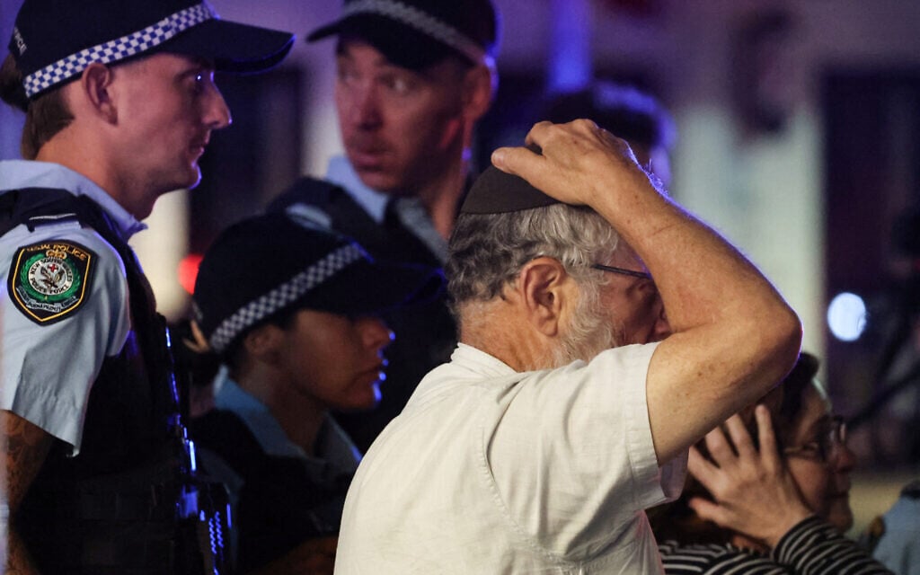 A member of the Australian Jewish community reacts as he walks with police toward the scene of a deadly terror shooting at Bondi Beach in Sydney on December 14, 2025. (DAVID GRAY / AFP) A member of the Australian Jewish community reacts as he walks with police toward the scene of a deadly terror shooting at Bondi Beach in Sydney on December 14, 2025. (DAVID GRAY / AFP)