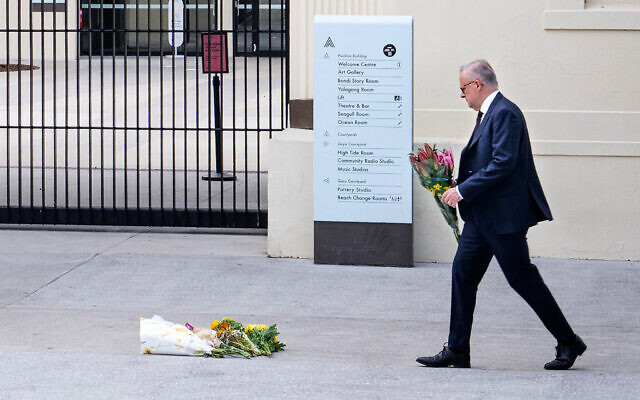 A handout photo taken and released by the Australian Prime Minister's Office on December 15, 2025, shows Australian Prime Minister Anthony Albanese laying flowers at the Bondi Pavilion at Bondi Beach, the scene of a deadly terror shooting  targeting a Hanukkah event, 15 people were killed. (AFP / AUSTRALIAN PRIME MINISTER'S OFFICE)