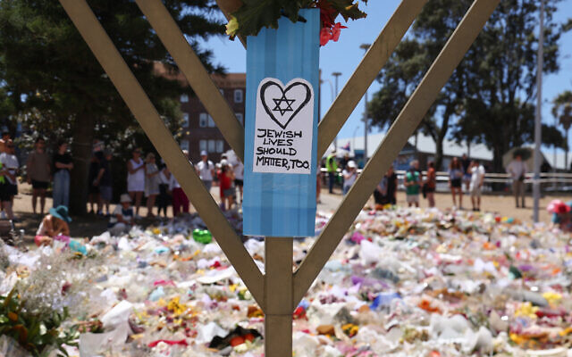 A sign reading 'Jewish Lives Should Matter, Too' is seen at the floral tributes area outside Bondi Pavilion in Sydney on December 18, 2025, to honor victims of the Hanukkah terror attack targeting the Jewish community (DAVID GRAY / AFP) A sign reading 'Jewish Lives Should Matter, Too' is seen at the floral tributes area outside Bondi Pavilion in Sydney on December 18, 2025, to honor victims of the Hanukkah terror attack targeting the Jewish community (DAVID GRAY / AFP)