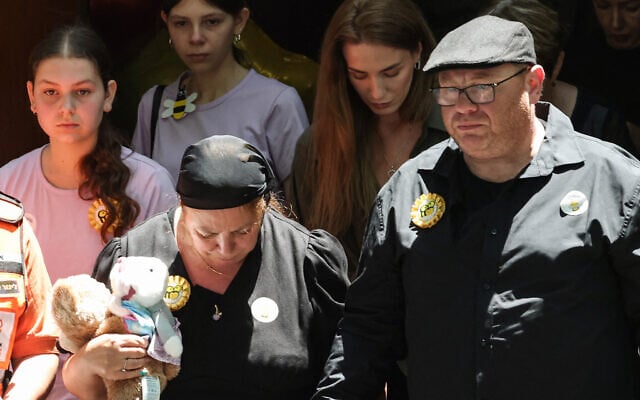 Valentyna (L), mother of 10-year-old Matilda, who was killed in the December 14 Bondi Beach terror shooting attack, and Matilda's father (R) leave behind their daughter's coffin after the funeral service in Sydney on December 18, 2025. (DAVID GRAY / AFP)