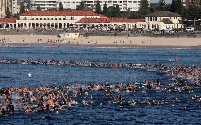 Surfers and swimmers congregate in the water at Bondi Beach as they participate in a tribute for the victims of the terror attack targeting a Hanukkah event at the beach, in Sydney on December 19, 2025. (David Gray/AFP) Surfers and swimmers congregate in the water at Bondi Beach as they participate in a tribute for the victims of the terror attack targeting a Hanukkah event at the beach, in Sydney on December 19, 2025. (David Gray/AFP)