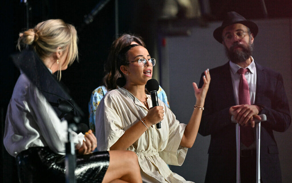 Chaya Dadon (center), who was wounded in the December 14 Bondi Beach terror attack targeting a Jewish event, speaks on stage during the memorial held for the victims of the shooting, December 21, 2025. (Saeed KHAN / AFP)