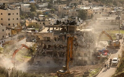 Excavators demolish a building constructed without a permit in the Wadi Qaddum area near the Silwan neighborhood of East Jerusalem on December 22, 2025. (AHMAD GHARABLI / AFP)
