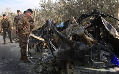 A Lebanese soldier inspects the wreckage of a car that was targeted in an Israeli airstrike near Sidon, in southern Lebanon, on December 22, 2025. (Mahmoud ZAYYAT / AFP)