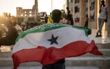 Illustrative: A man holds a flag of Somaliland in front of the Hargeisa War Memorial monument in Hargeisa on November 7, 2024. (Luis Tato/AFP)
