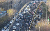 Storekeepers and traders walk over a bridge during a protest against the economic conditions and Iran's embattled currency in Tehran on December 29, 2025. (FARS NEWS AGENCY / AFP)