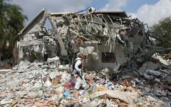 An Israeli soldier walks by a house destroyed by Hamas terrorists in Kibbutz Be'eri, October 11, 2023. (AP/Baz Ratner)