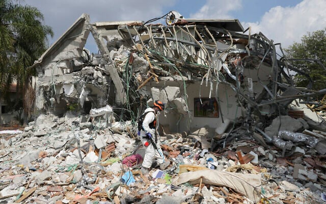 An Israeli soldier walks by a house destroyed by Hamas terrorists in Kibbutz Be'eri, October 11, 2023. (AP/Baz Ratner) An Israeli soldier walks by a house destroyed by Hamas terrorists in Kibbutz Be'eri, October 11, 2023. (AP/Baz Ratner)
