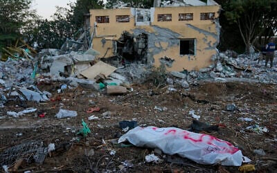 A Hamas terrorist in a body bag is seen in Kibbutz Be'eri, Oct. 11, 2023. (AP/Ohad Zwigenberg)