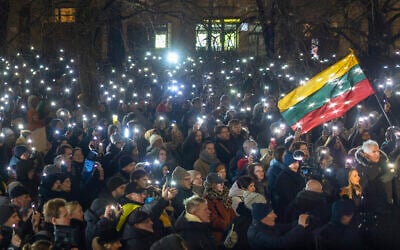 People protest at Independence Square outside Parliament in Vilnius, Lithuania, against the inclusion of the Nemunas Dawn party and Remigijus Zemaitaitis, accused of antisemitism, into the country's ruling coalition, November 21, 2024. (AP/Mindaugas Kulbis)