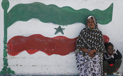 A woman and child relax next to a mural of Somaliland's flag, in Hargeisa, Somaliland, a semi-autonomous breakaway region of Somalia, on February 9, 2022. (AP Photo/Brian Inganga)