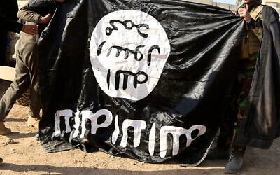 Illustrative: Iraqi Army soldiers celebrate as they hold a flag of the Islamic State group they captured during a military operation to regain control of a village outside Mosul, Iraq, November 29, 2016. (AP Photo/Hadi Mizban, file)